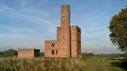 The 18th-century brick Tower, with a square tower and a taller round tower, both with crenellations,  is now let as a holiday cottage